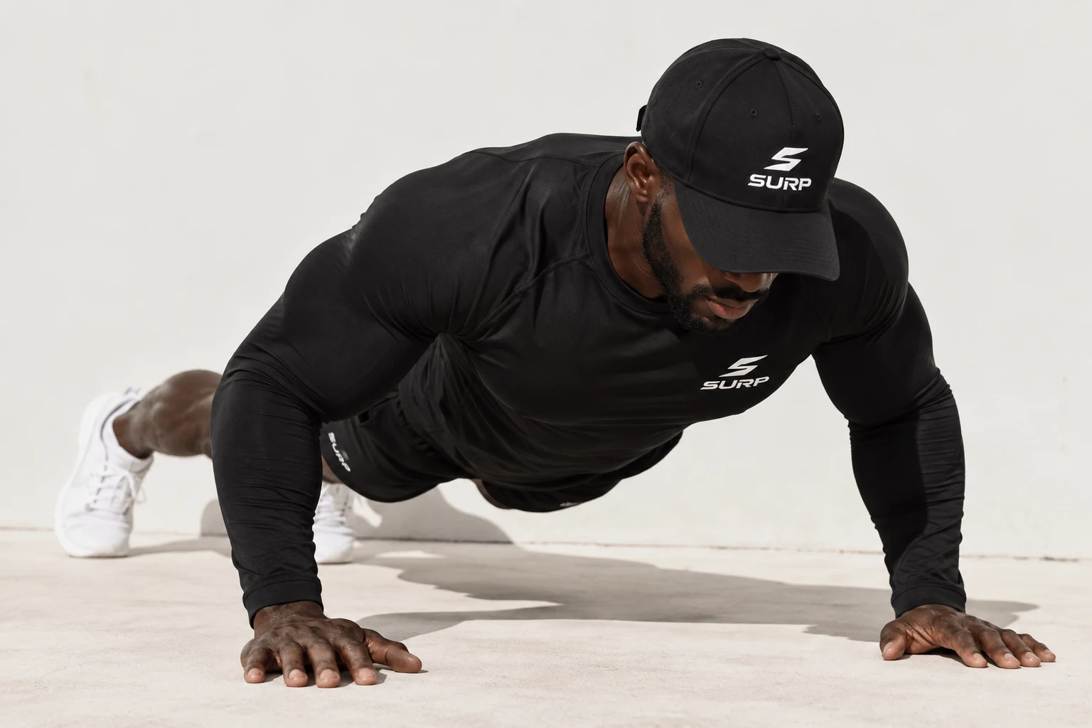 Male SURP athlete performing a push-up in black training wear